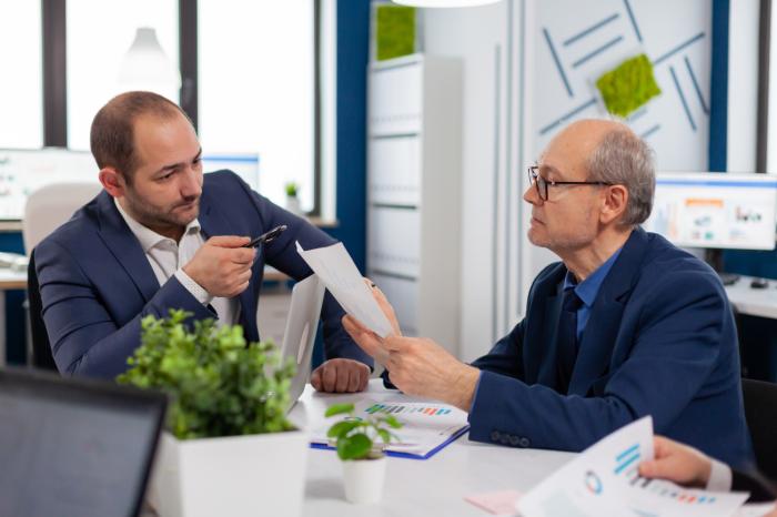 two older investment advisors looking at documents in an office financial advisor transitions