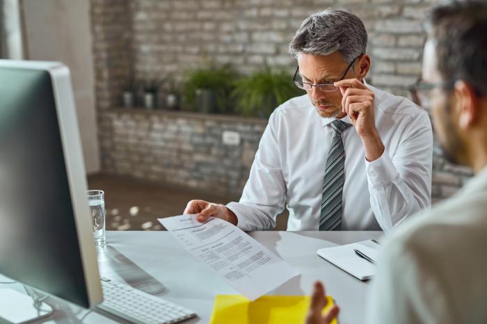 financial advisor at desk looking at documents with client financial advisor transitions